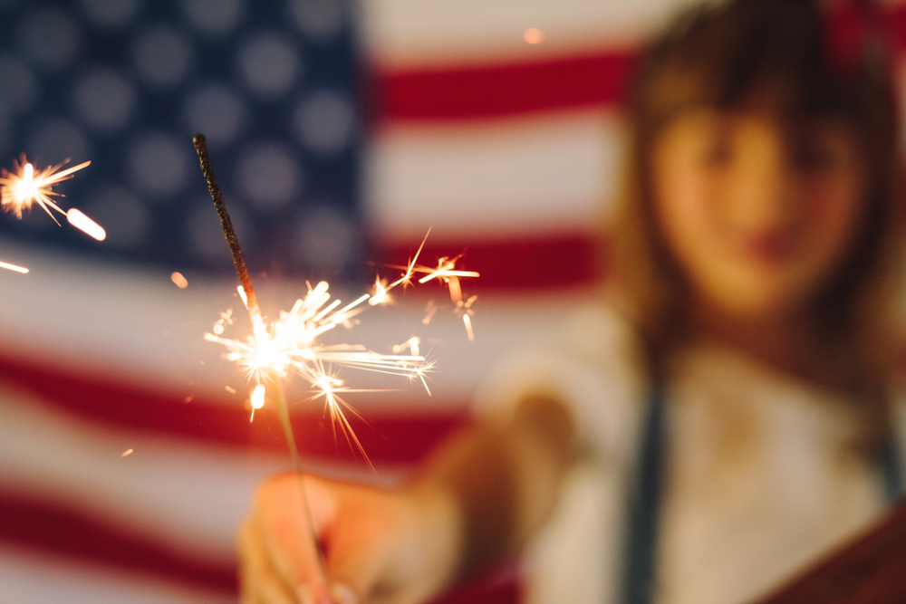 Child playing with sparklers on Independence Day — holiday pet safety awareness