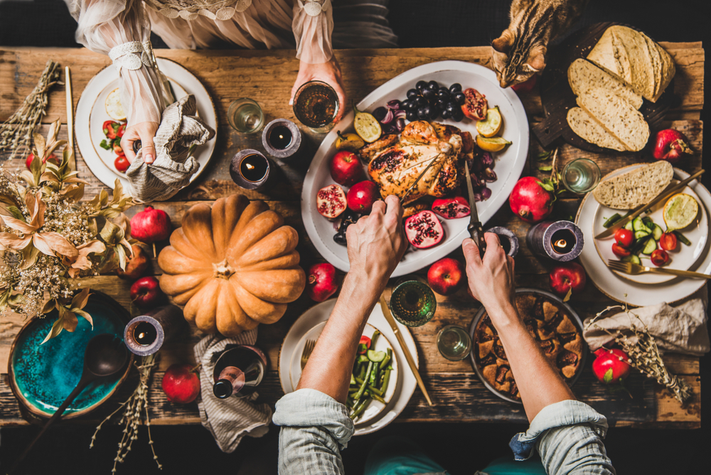 Thanksgiving table with roasted chicken and vegetables — holiday foods to avoid feeding pets